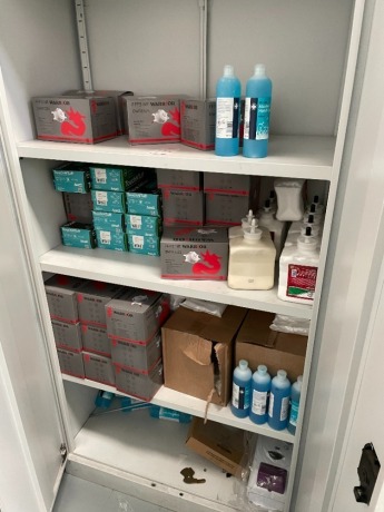 Contents of double door cabinet to include Warrior DWRE025 disposable face masks, hand sanitzer and hand soap